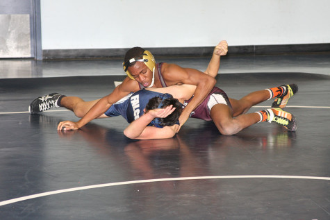 Malik Grant tries to pin his opponent from Wagner High School in a dual meet