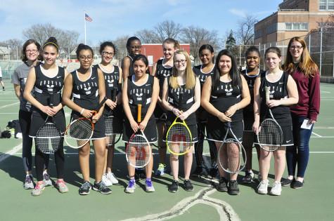 The girls tennis team with their coaches at practice.