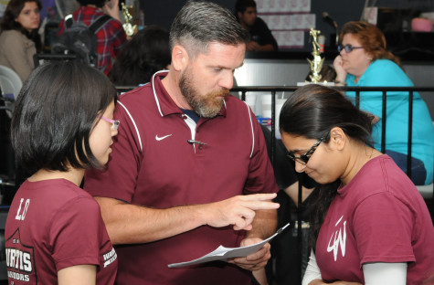 Mr. Barrett giving advice to Sum Lo and Arshia Lodhi.