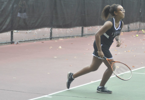 Alecia Miguel prepares herself to hit the tennis ball.