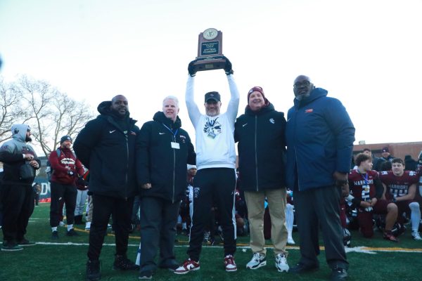 Coach Gambardella holding the PSAL City Championship trophy up high.