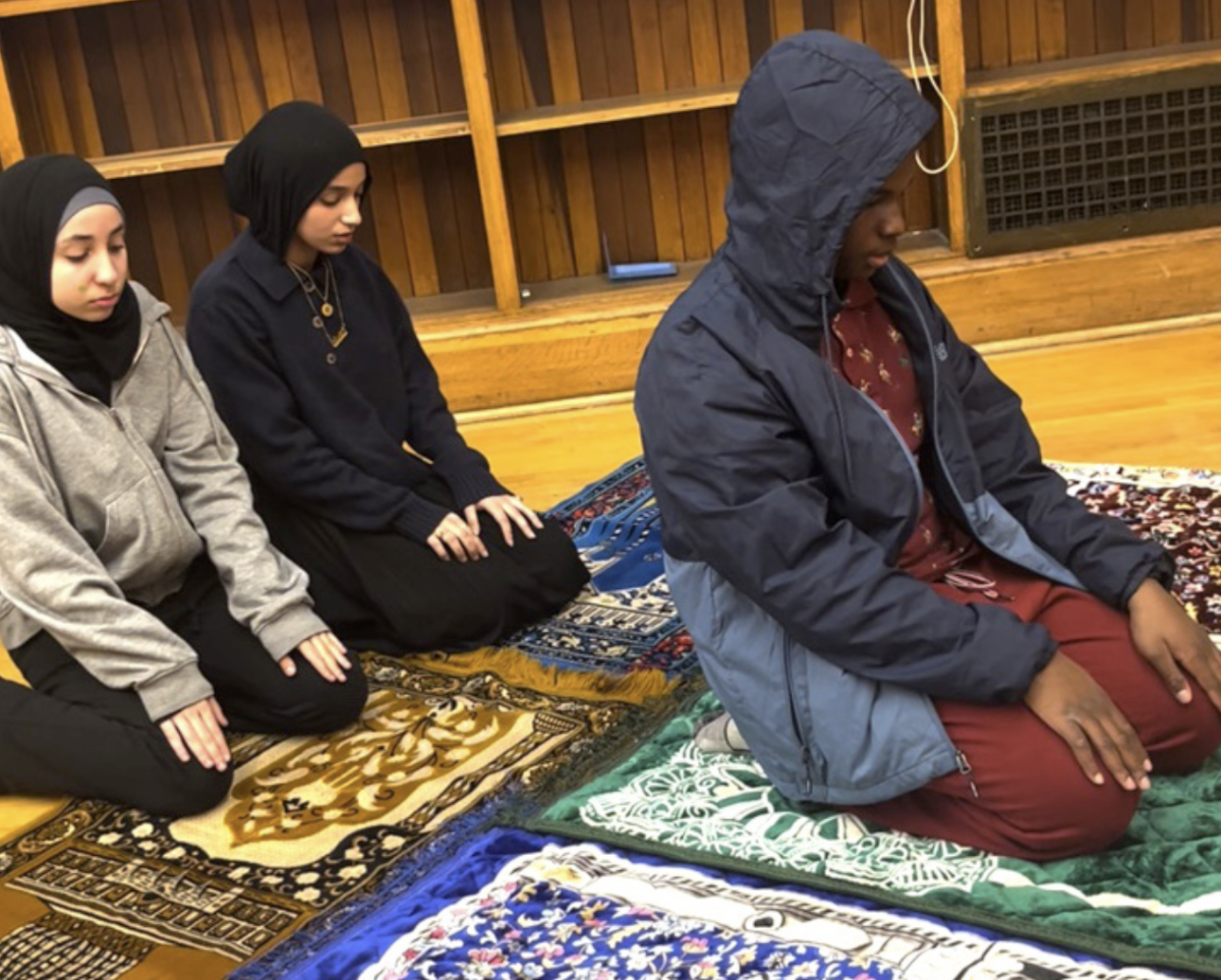 Muslim students kneeling in prayer for Ramadan.
